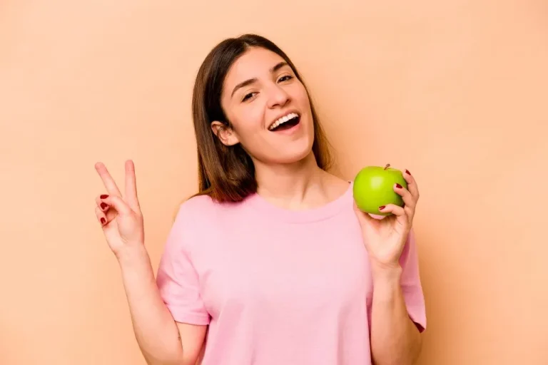 בחורה צעירה שמחה אוכלת תפוח - חילוף חומרים מהיר