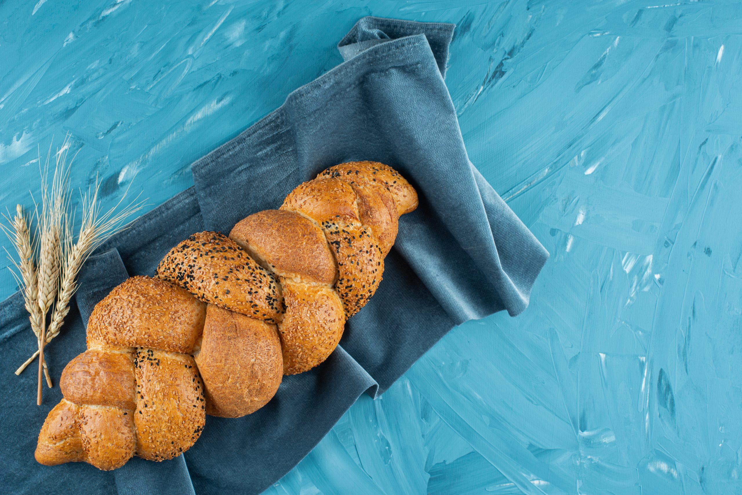 Freshly baked braided bread loaf on a dark tablecloth . High quality photo